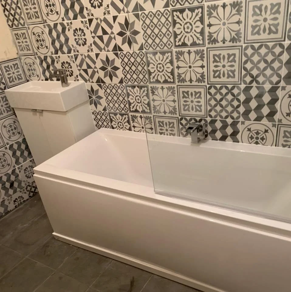 Bath, glass screen and patterned wall tiles